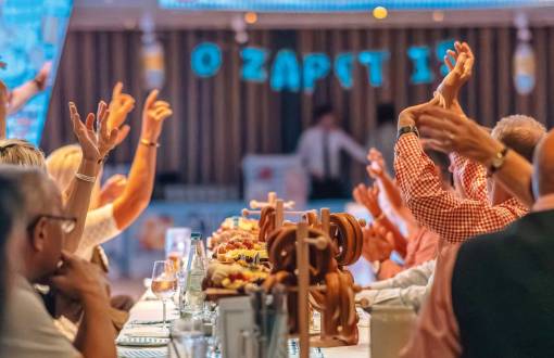 Gäste feiern mit erhobenen Armen beim 4. Binzer Oktoberfest mit Bier, Wein, Brezeln und festlichen Dekorationen im Arkona Strandhotel.