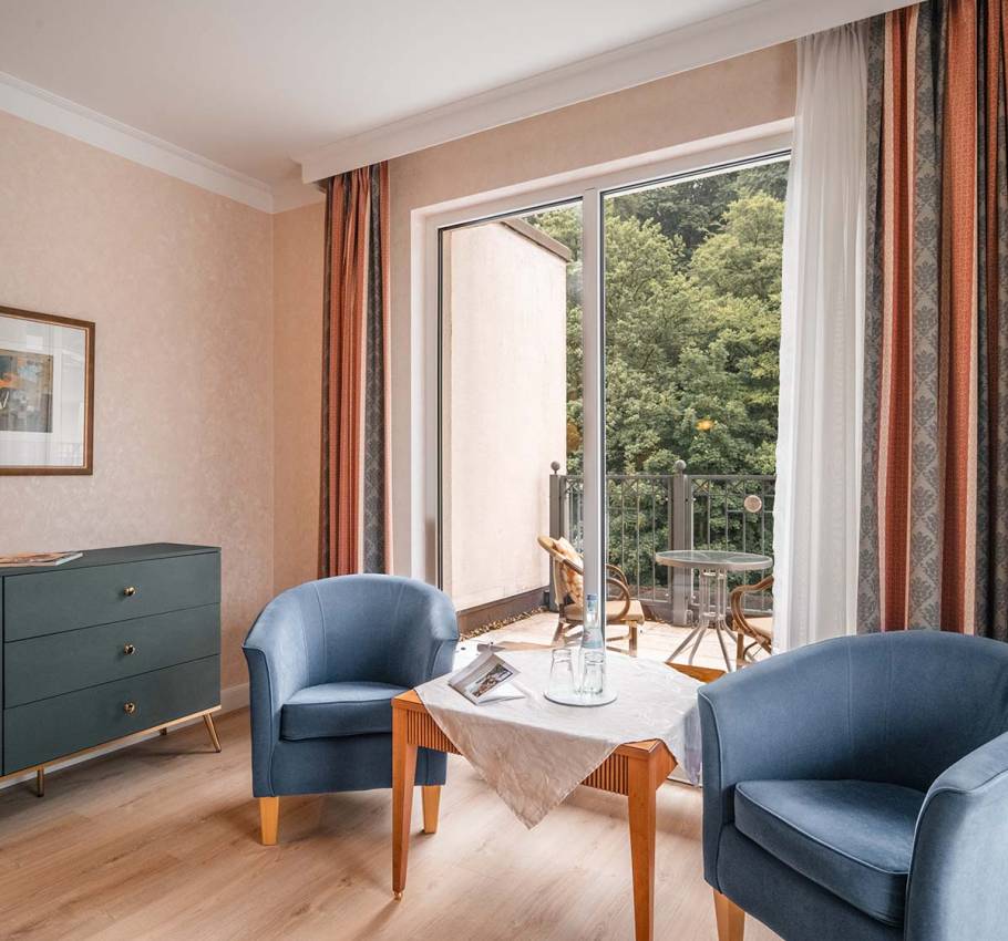 Elegant Granitz Deluxe Room at the Grand Hotel Binz with roof terrace, lounge furniture, and a view of the countryside.