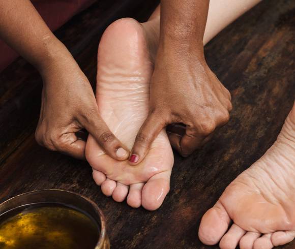 Behutsame Streichbewegungen mit Massageöl an den Fußunterseiten.