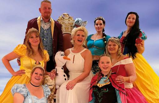 Nicole Mühle umgeben von Darstellern in Disney-Kostümen bereit für den Disney-Abend im Arkona Strandhotel in Binz.