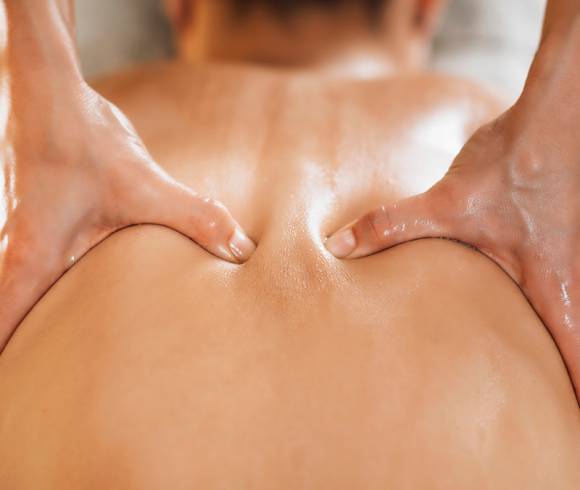 Ayurvedische Rückenmassage mit warmem Öl zur Lockerung von Verspannungen und zur Förderung der Durchblutung.