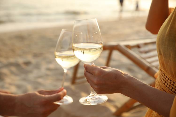 Gästepaar beim Anstoßen am Strand vor dem Grand Hotel Binz – Symbol für Green Stay und gemeinsame Umweltaktionen