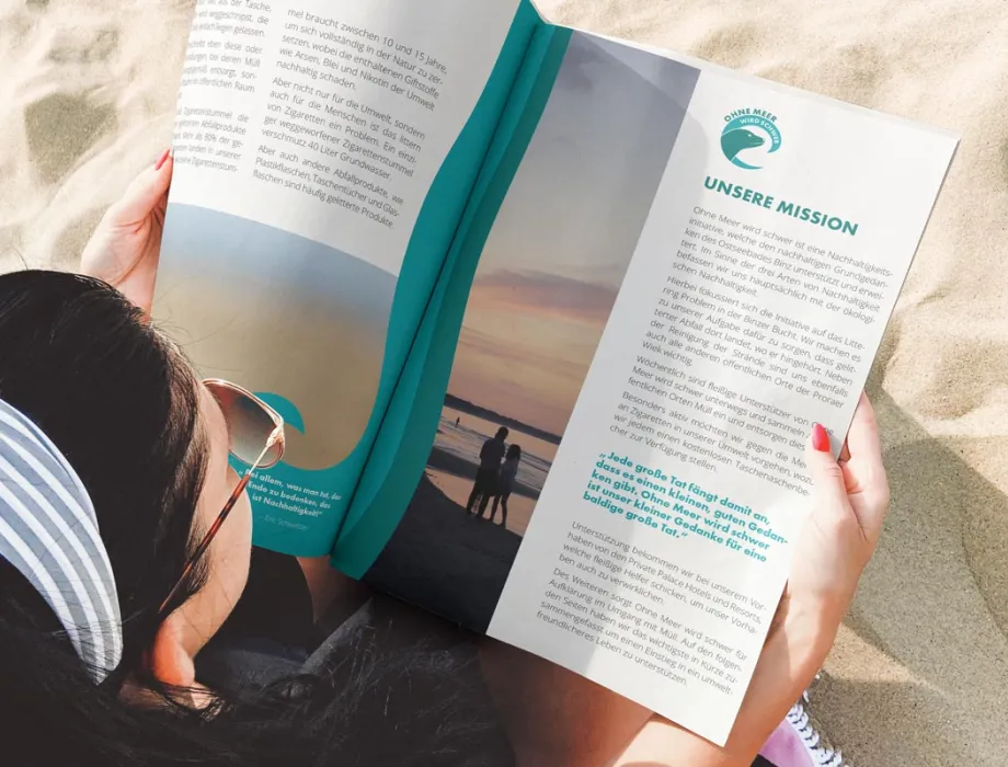 Frau am Strand mit OMWS-Magazin – Grand Hotel Binz beteiligt sich an der Nachhaltigkeitsbewegung „Ohne Meer wird schwer“