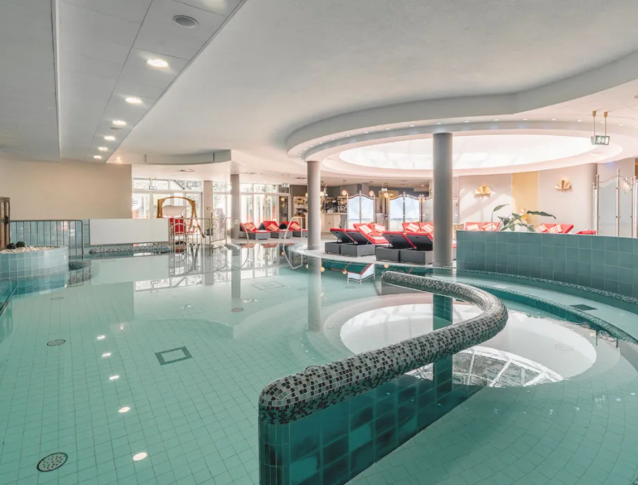Überblick über den Poolbereich des Grand Hotel Binz mit maritimer Deko und Liegen, perfekt für einen Wellnessurlaub auf Rügen.