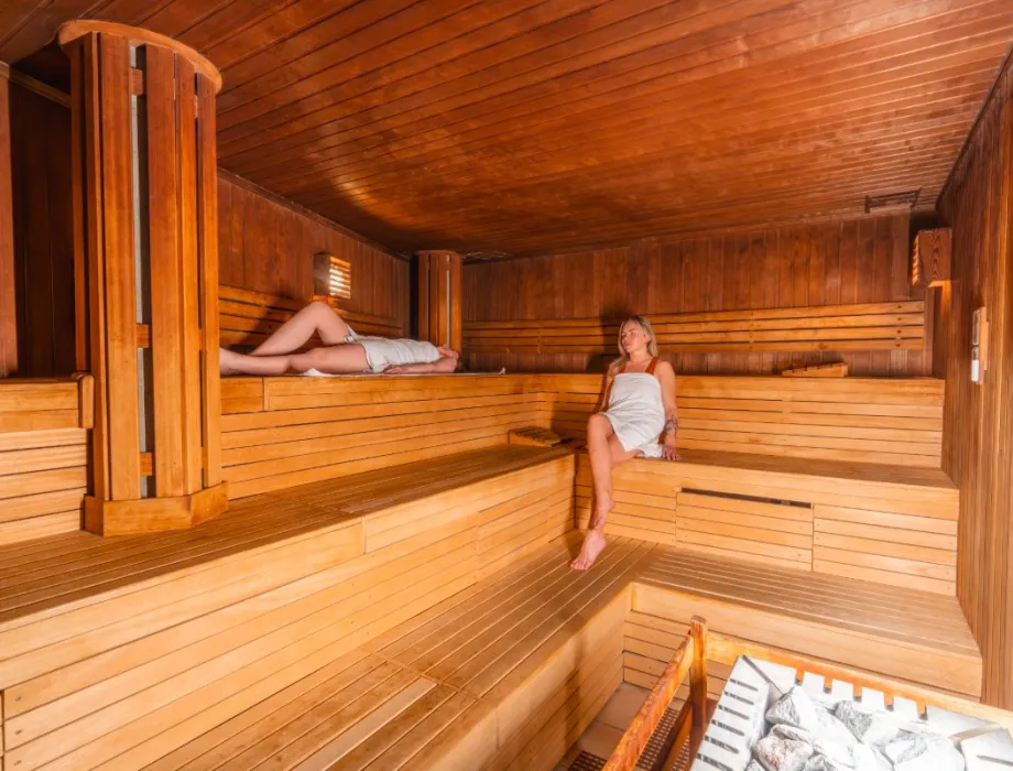 Zwei Frauen genießen die Wärme in der Sauna im Wellness im Grand Hotel Binz auf Rügen.