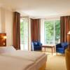 Ein Hotelzimmer mit großen Fenstern und Terrasse und Blick ins Grüne
