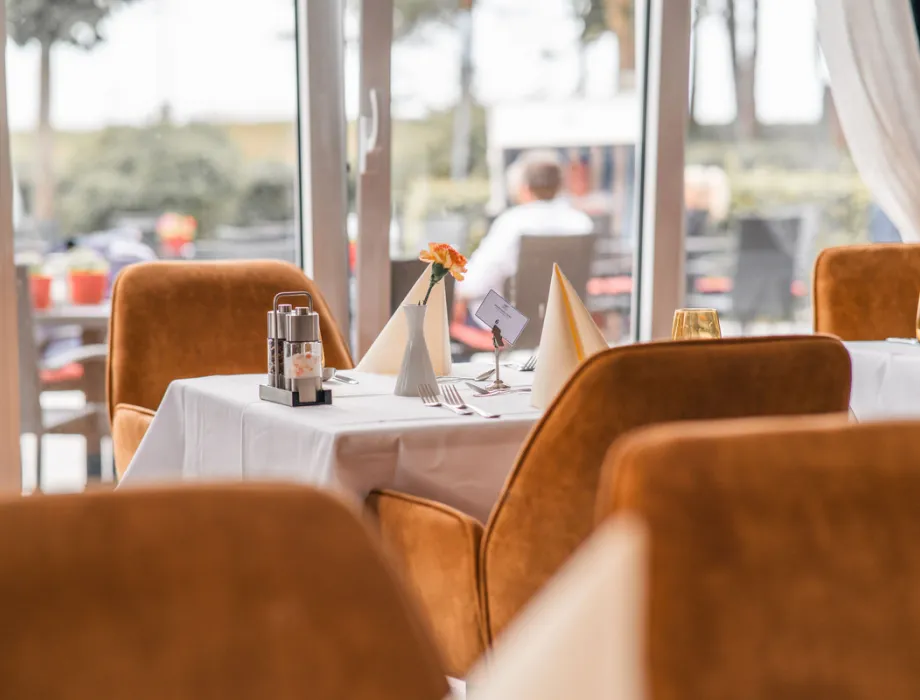 Elegant gedeckter Tisch im Restaurant Ruiani des Grand Hotel Binz mit Blick auf die Terrasse.