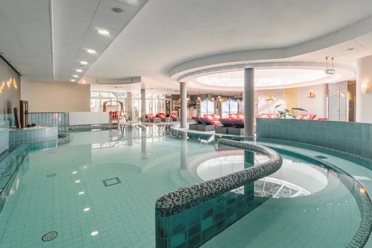 Überblick über den Poolbereich des Grand Hotel Binz mit maritimer Deko und Liegen, perfekt für einen Wellnessurlaub auf Rügen.