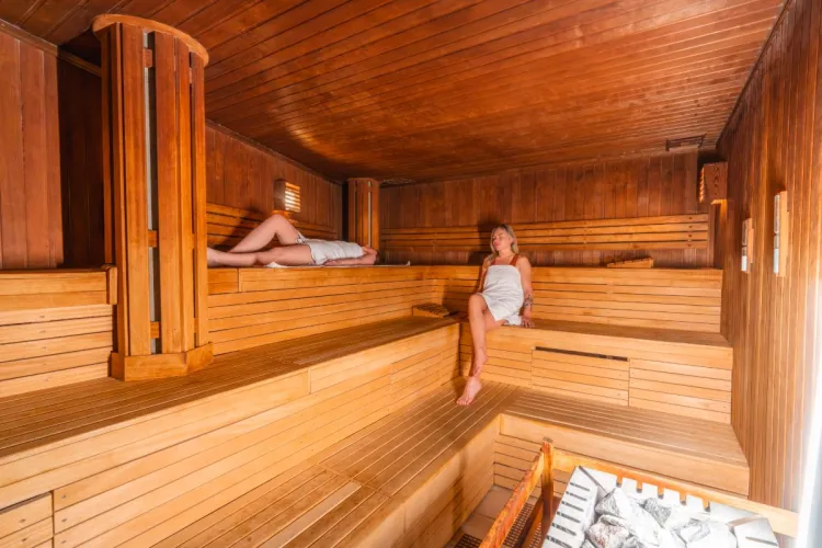 Zwei Frauen genießen die Wärme in der Sauna im Wellness im Grand Hotel Binz auf Rügen.