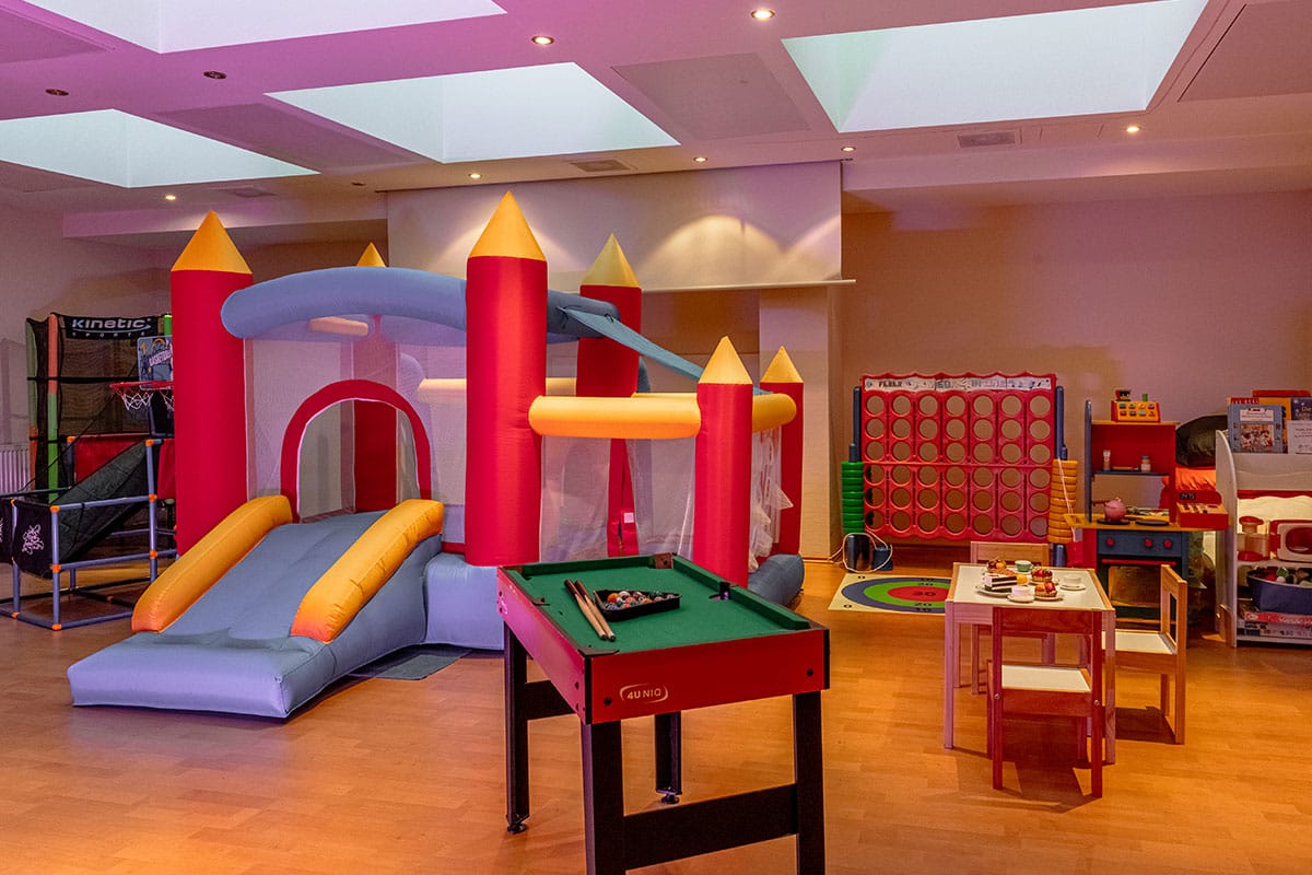 Ein Spielraum für Kinder mit Hüpfburg und verschiedenen Spielsachen im Hotel in Binz